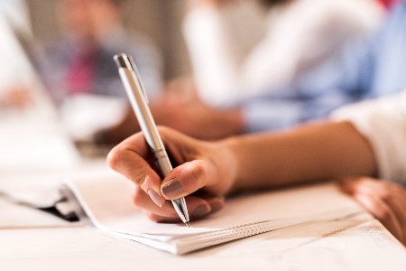 Person writes in notebook in Naugle CommLab